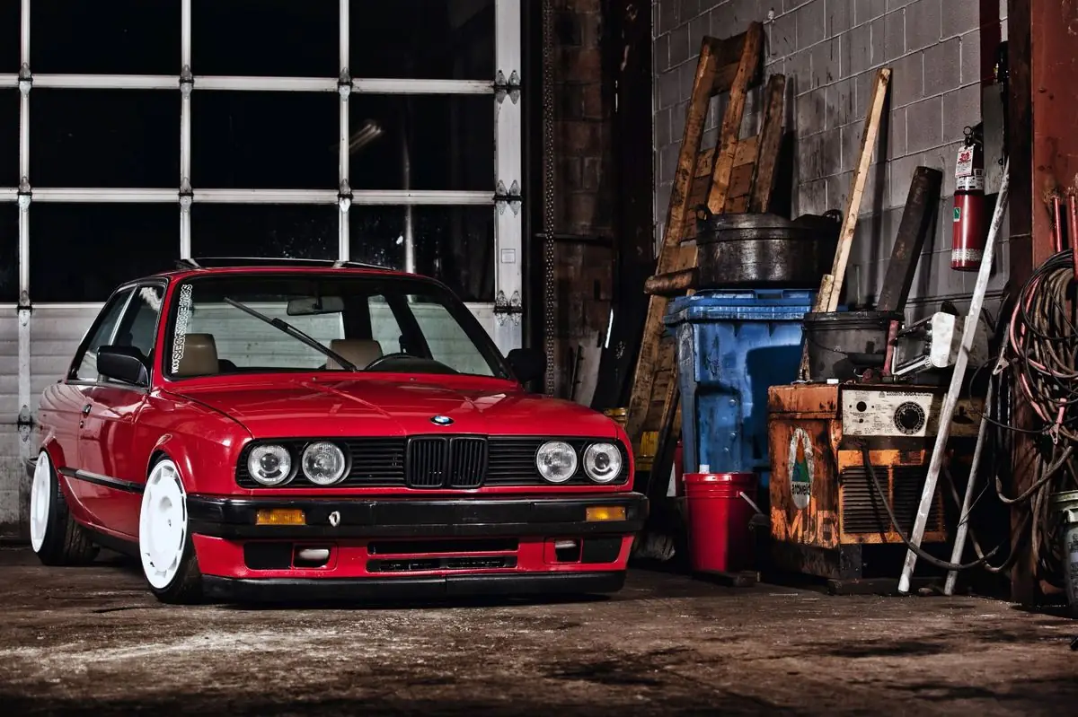 Röd BMW E30 i ett garage